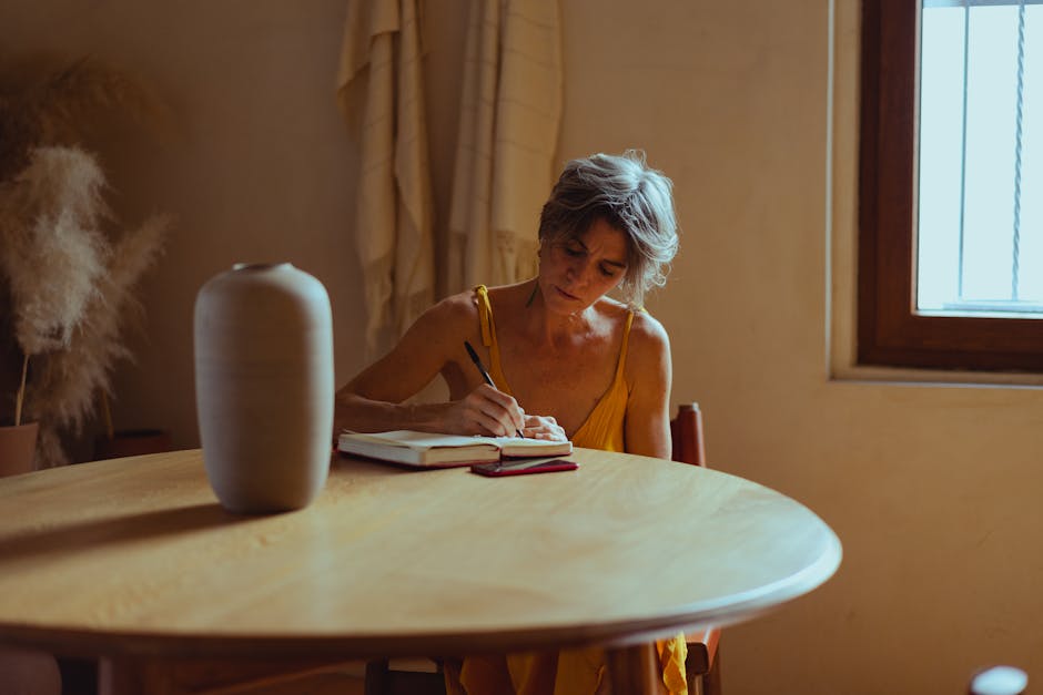 Senior woman writes in a diary at home. Warm, cozy setting highlighting positive aging and leisure.