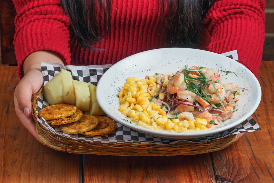 Close-up of seafood ceviche with corn, slices of potatoes, and patacones in a basket.