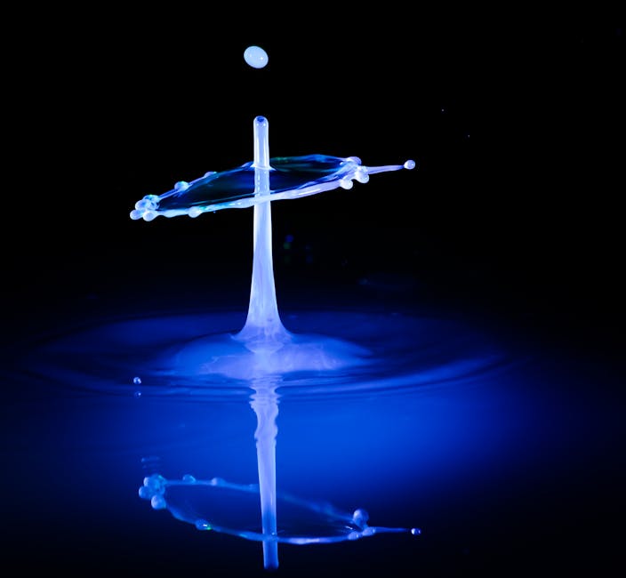 Captivating high-speed photograph of water drop collision under dramatic lighting, showcasing fluid dynamics.
