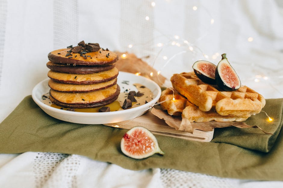 Tasty pancakes and waffles served with chocolate and fresh figs on a cozy setup.