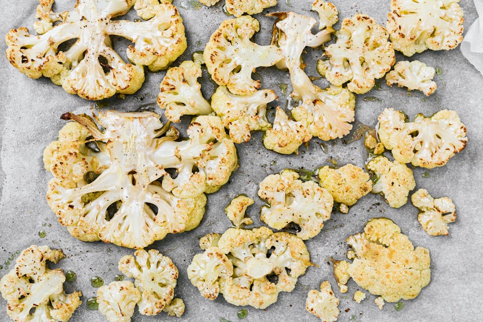 Crispy roasted cauliflower slices on a baking sheet, showcasing healthy eating.
