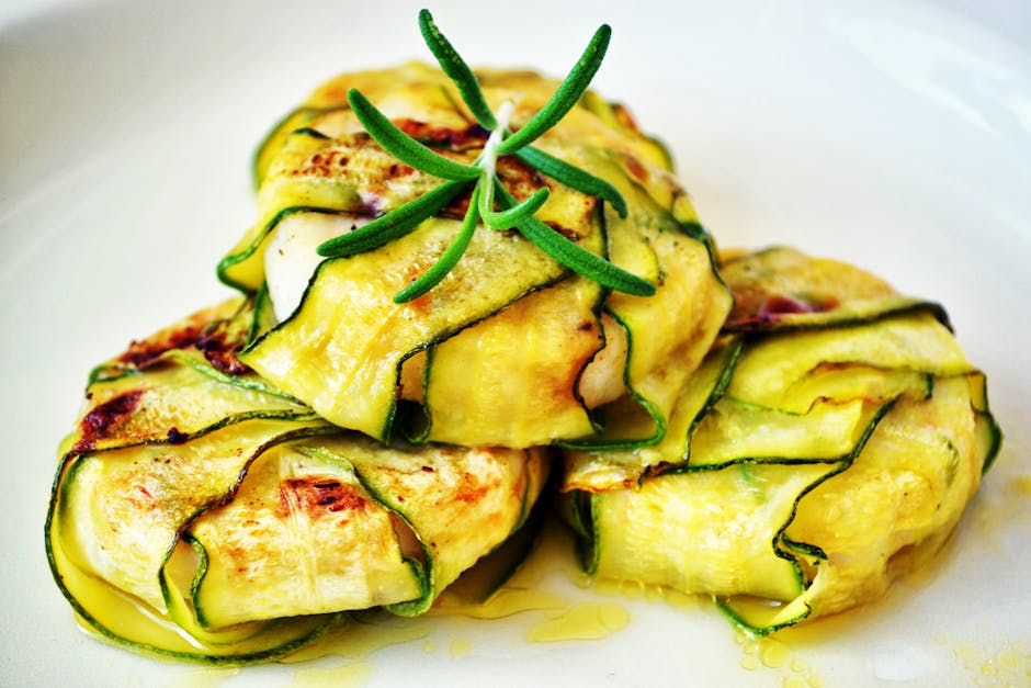 Delicious zucchini wraps stuffed with grilled chicken, presented with fresh rosemary garnish.